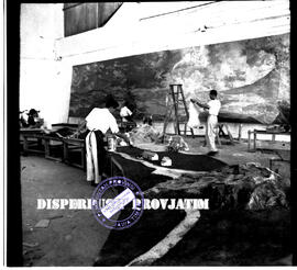 Tiga orang pekerja sedang sibuk menyelesaikan dekorasi untuk eksposisi /  pameran PMI (Palang Mer...