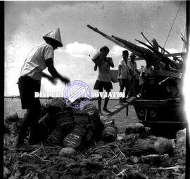 Suasana para buruh angkut sedang bongkar muat barang (kemasan ikan asin) ke dalam kapal di pelabu...